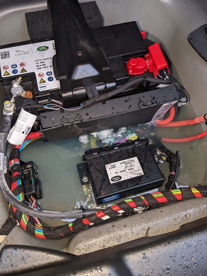 Land Rover control module sitting in standing water under a vehicle floor